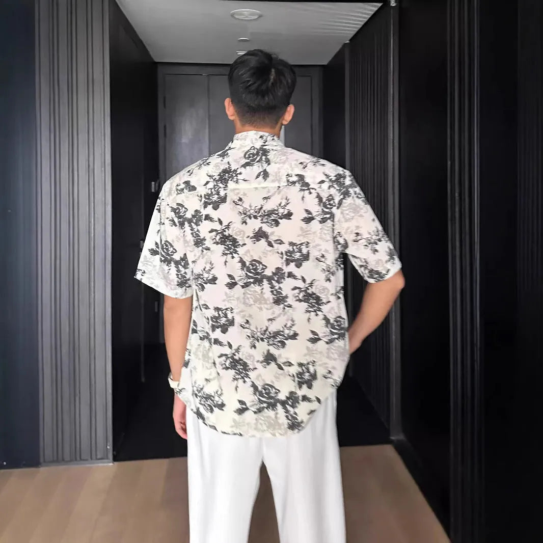 Man's loose-fit short sleeve shirt with printed floral pattern and pendant detail in black