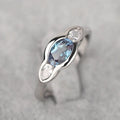 Geometric ellipse ring with inlaid zircon stones in white gold colour on female hand