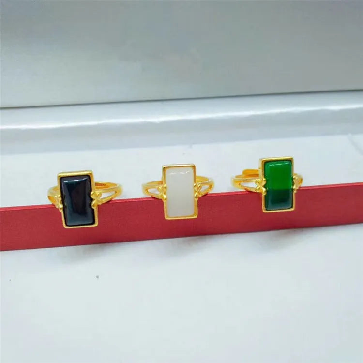 Adjustable brass gold-plated ring with an electroplated finish and a choice of black, green, or white gemstone.