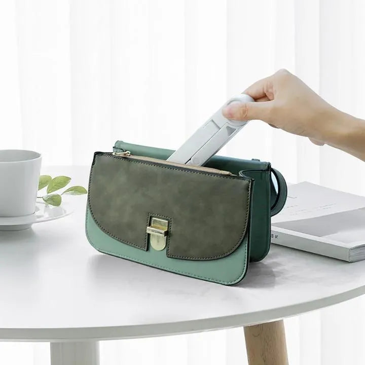 Black foldable tablet holder open in landscape mode holding a smartphone, showing its adjustable angle and non-slip base.