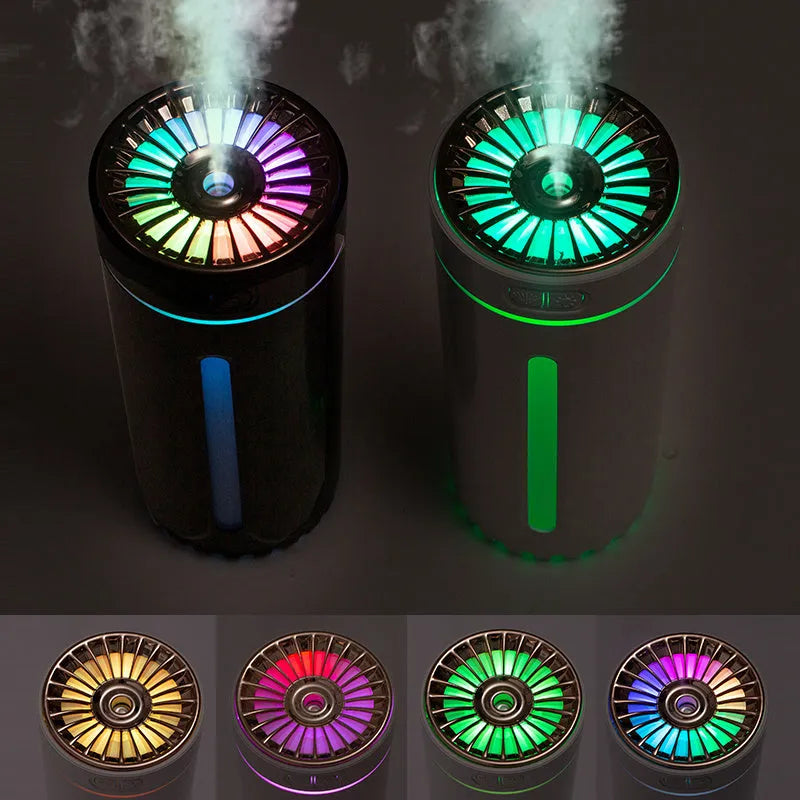 Black portable USB rechargeable car humidifier with colourful lights on a desk next to a cup