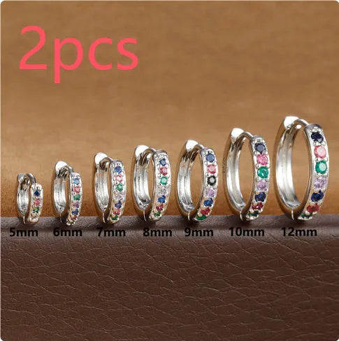 A pair of small circular zircon stud earrings with a metallic finish, shown next to a ruler indicating available sizes from 5mm to 12mm.