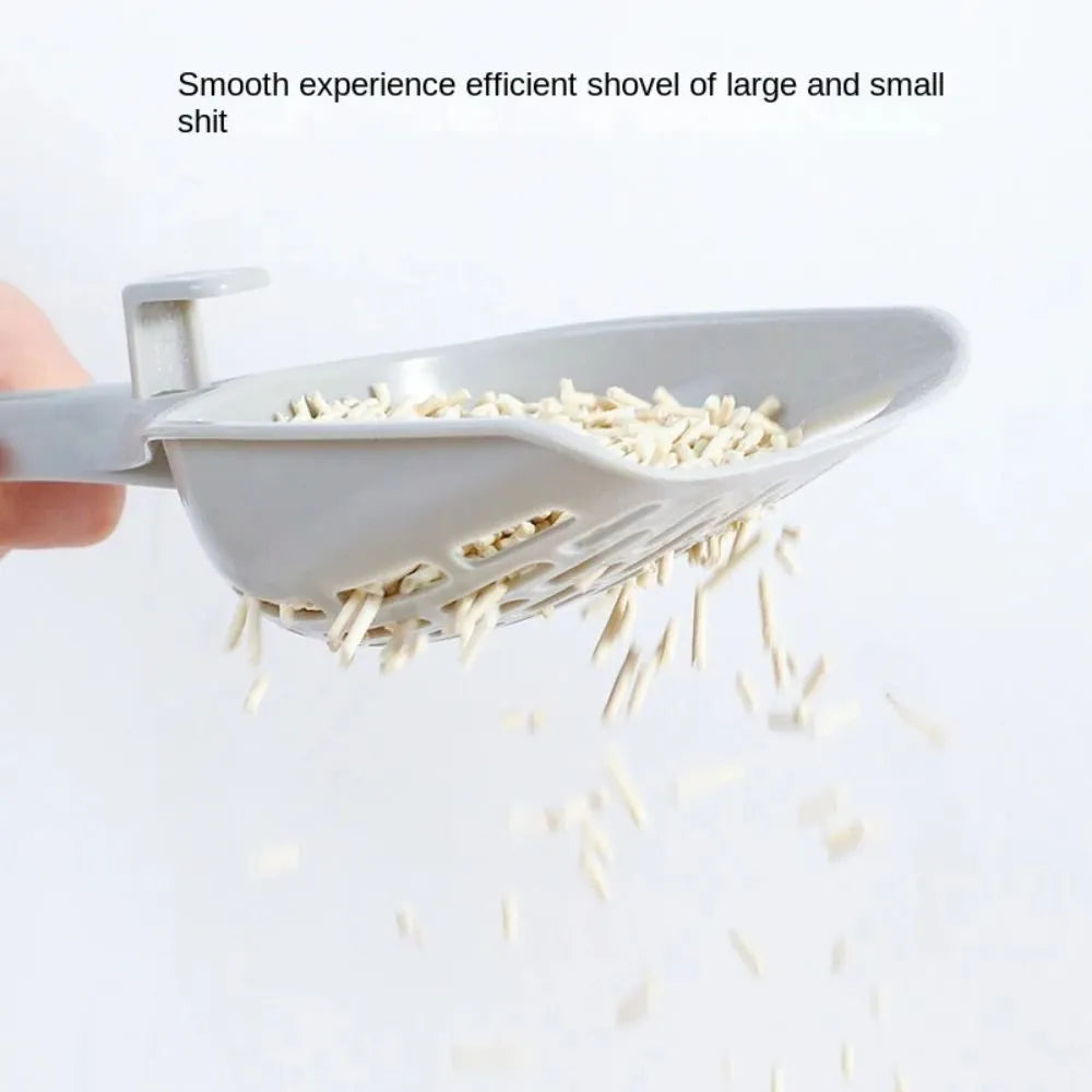 Grey plastic cat litter scoop resting on its matching comb-style base holder.