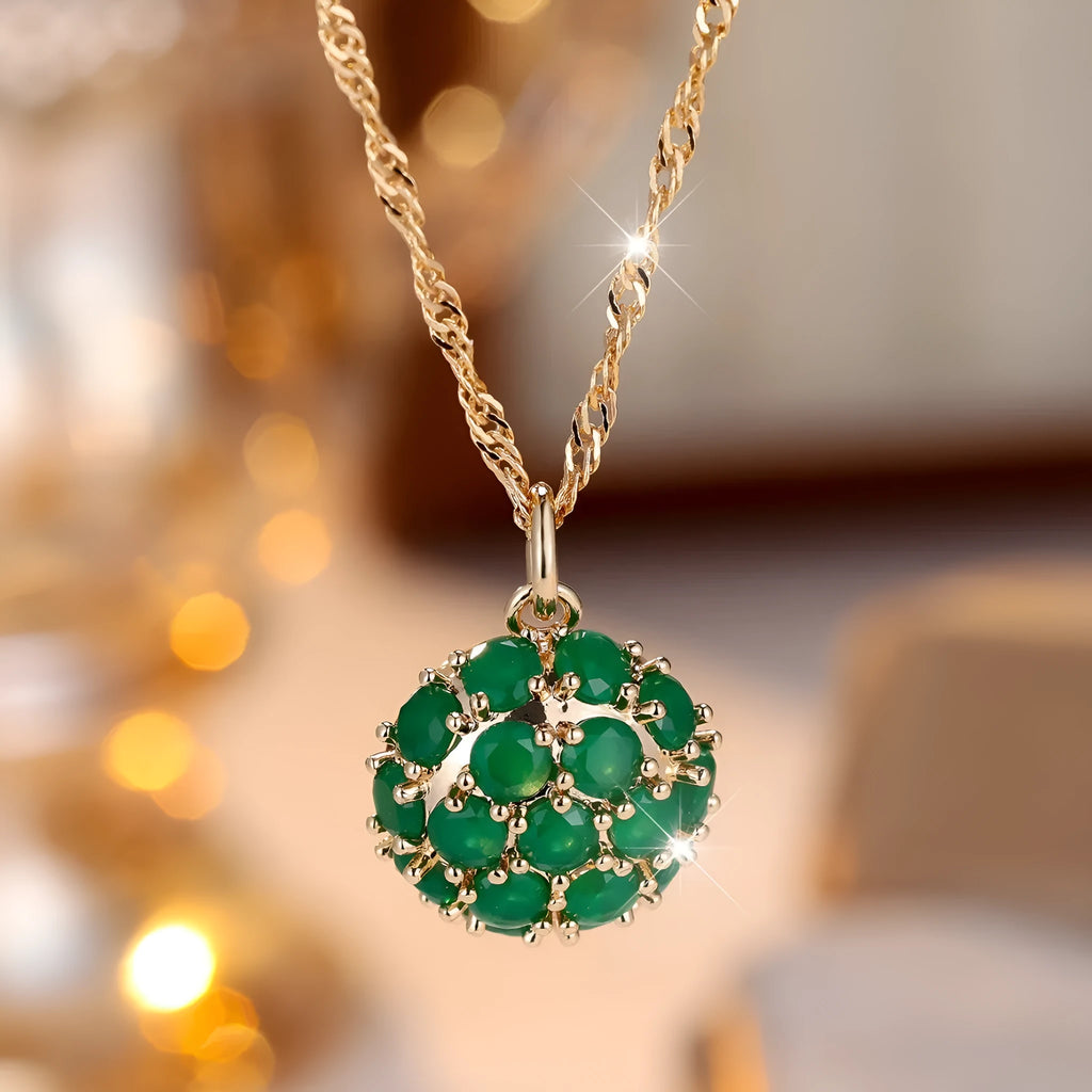 Round emerald pendant necklace with diamond setting on champagne gold chain