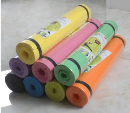 Red EVA fitness yoga mat showing texture and thickness, rolled partially with carry bag.