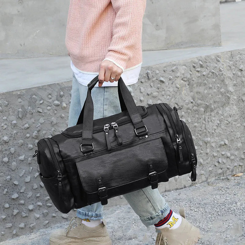 Black PU fabric travel duffle bag with a separate shoe compartment, shown with dimensions 52cm by 19cm by 27cm.