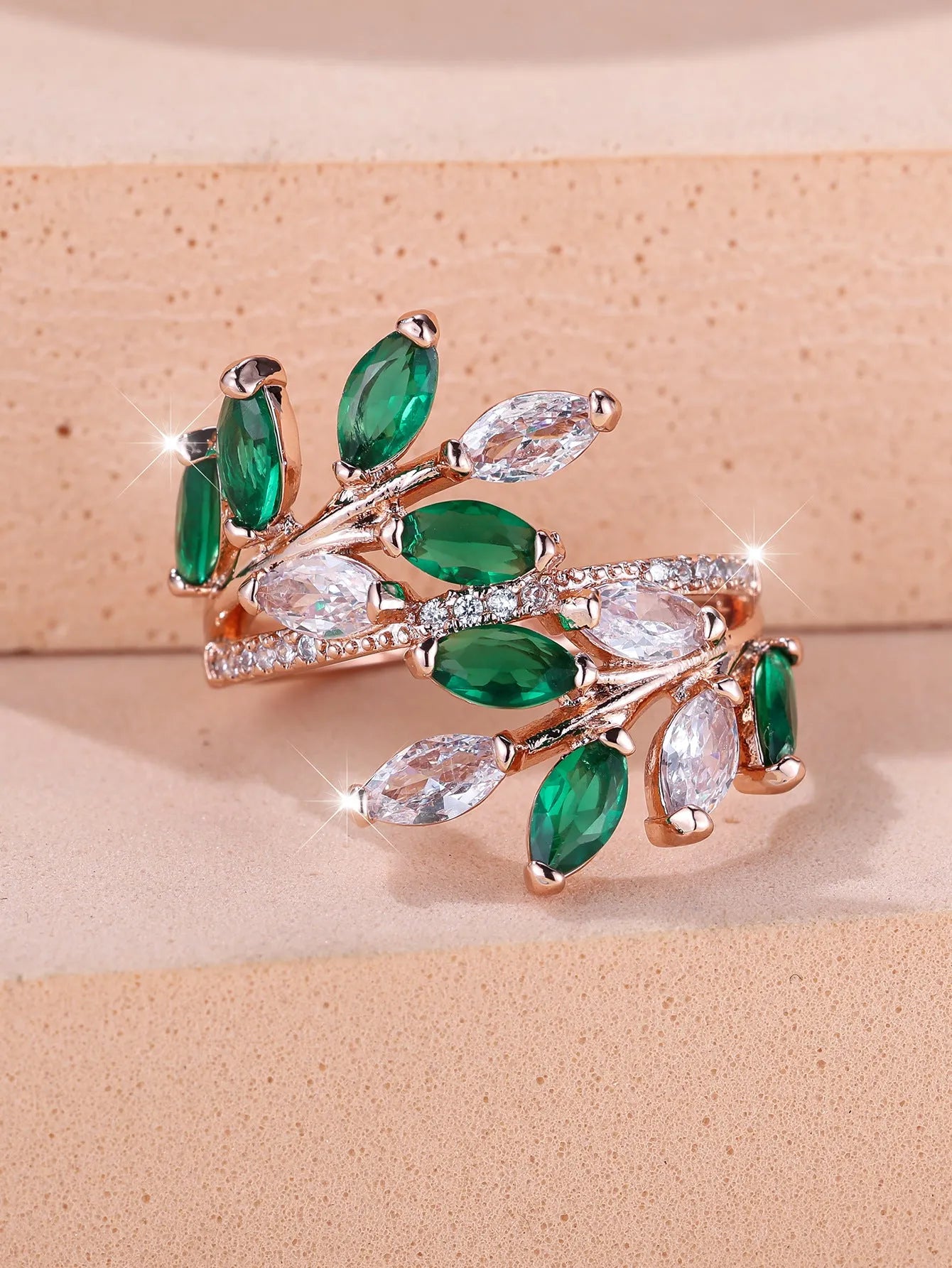 Adjustable opening copper leaf fashion ring with sparkling zirconia stones in a rose gold finish.