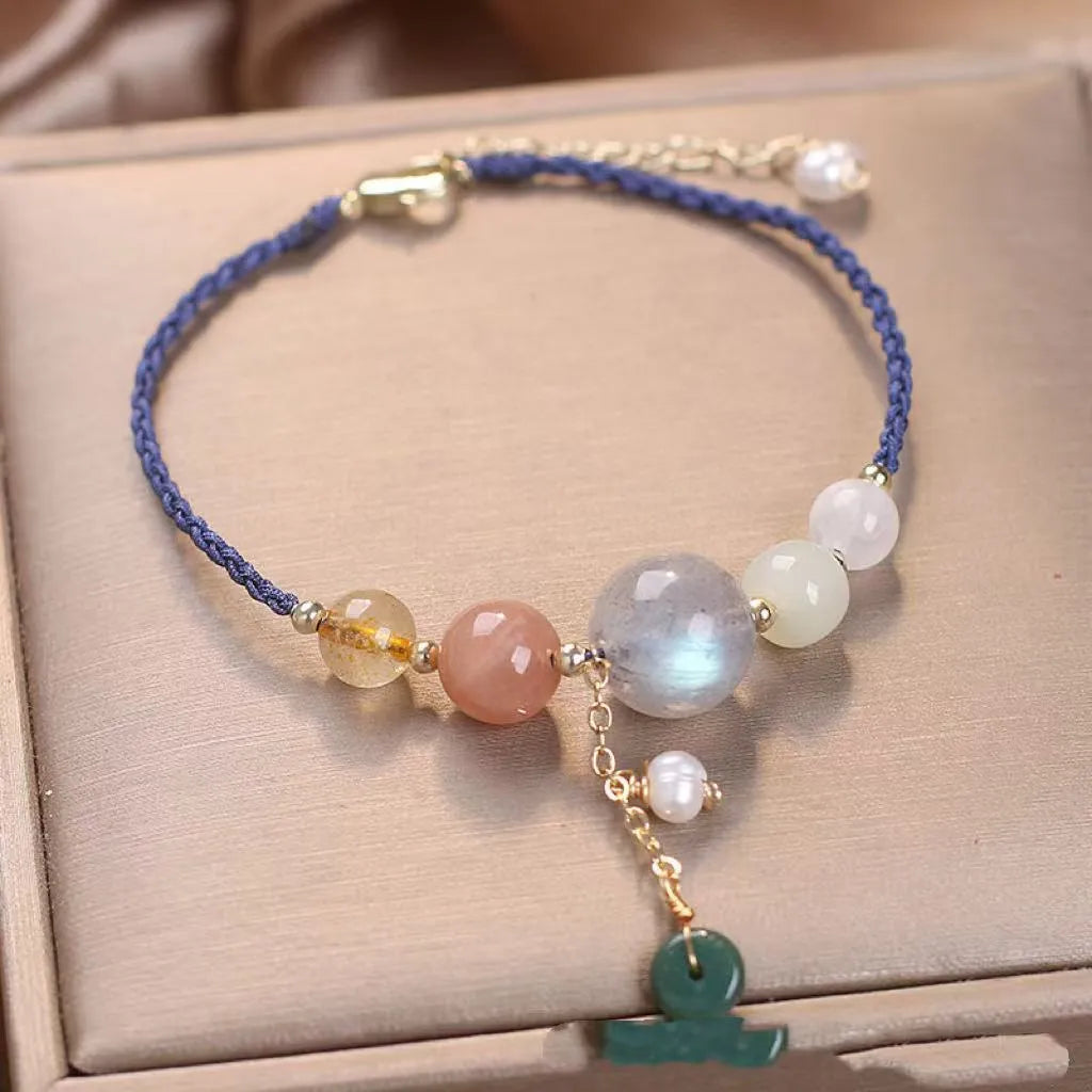 Close-up of a women's adjustable bracelet with crystal and sequin details on a hand-woven peace buckle clasp.