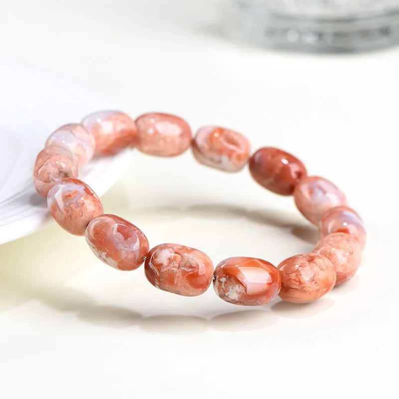 Natural cherry agate barrel bead bracelet with Ruyi design elements on wrist
