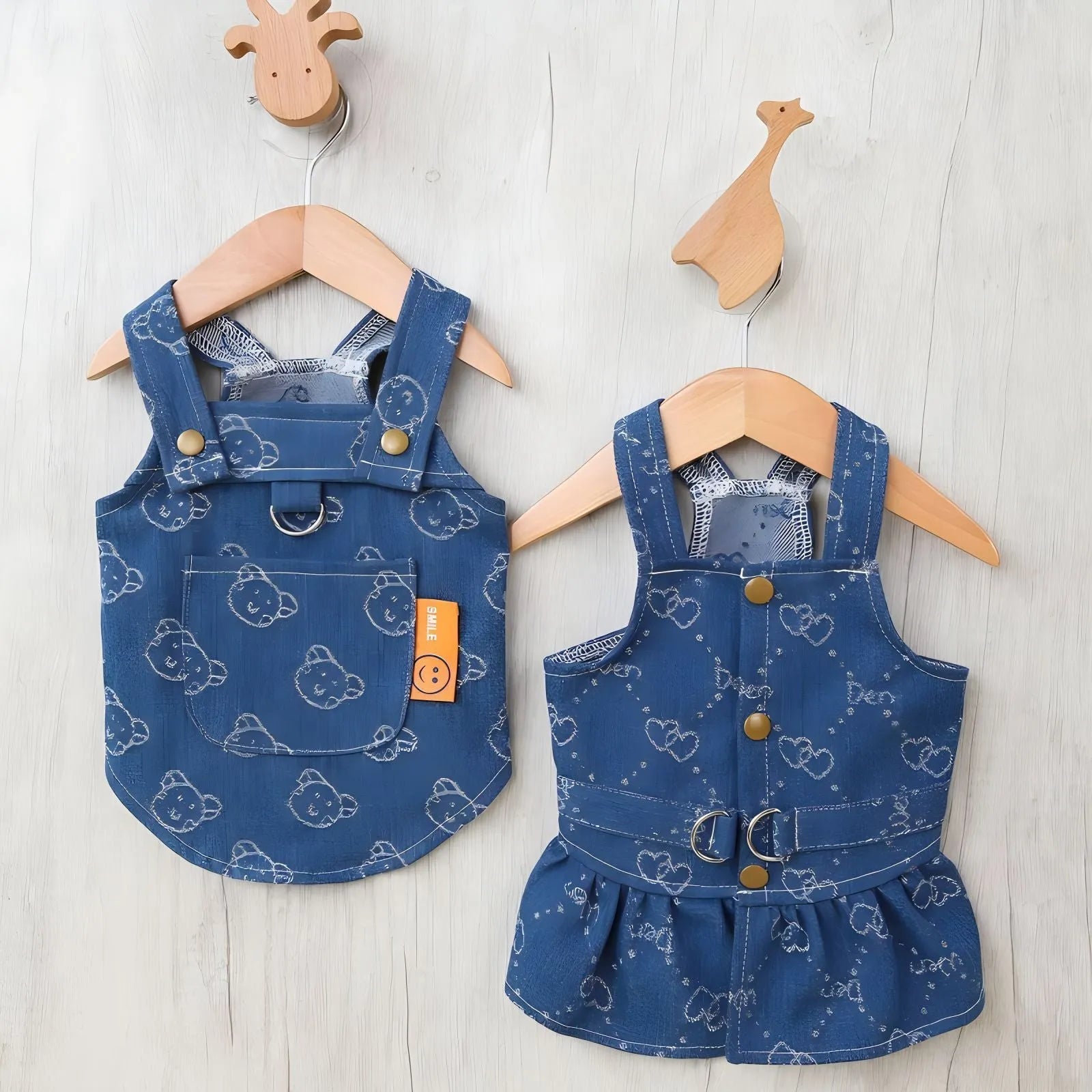A small dog wearing a light blue denim princess dress with a bracket-style skirt.