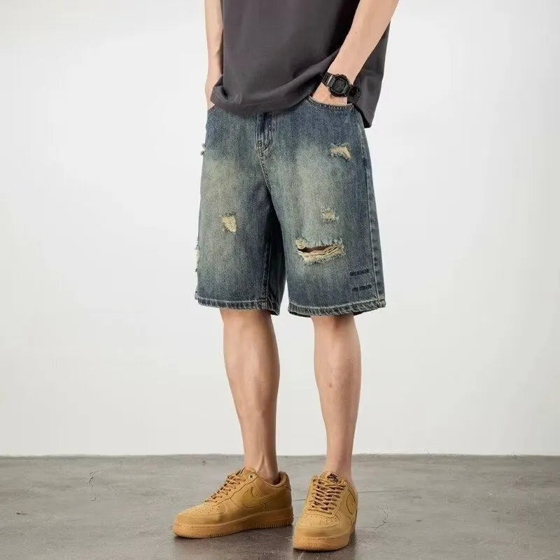 Retro blue denim men's shorts with distressed holes and straight leg cut on mannequin