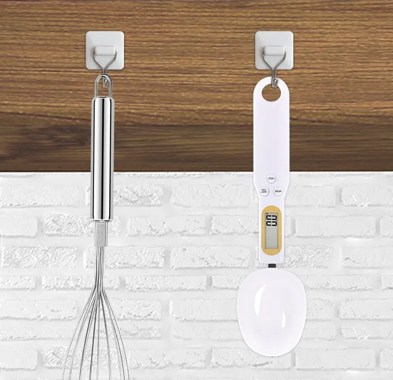 Black electronic digital measuring spoon scale on a kitchen worktop showing weight display.