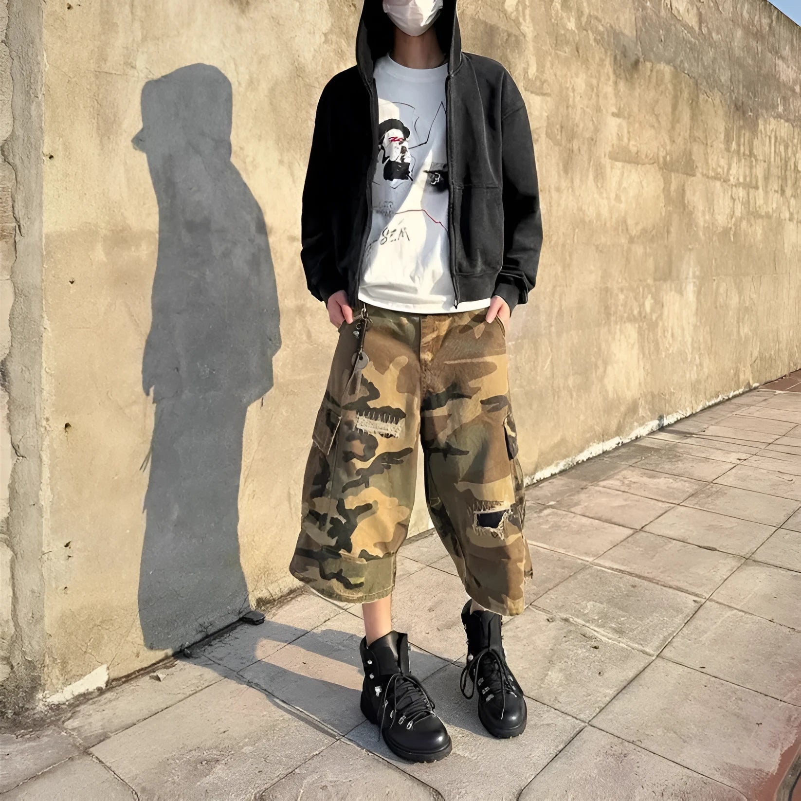 Men's camouflage-colour jeans with patch details, ripped fabric, and a cropped, loose straight-leg fit.