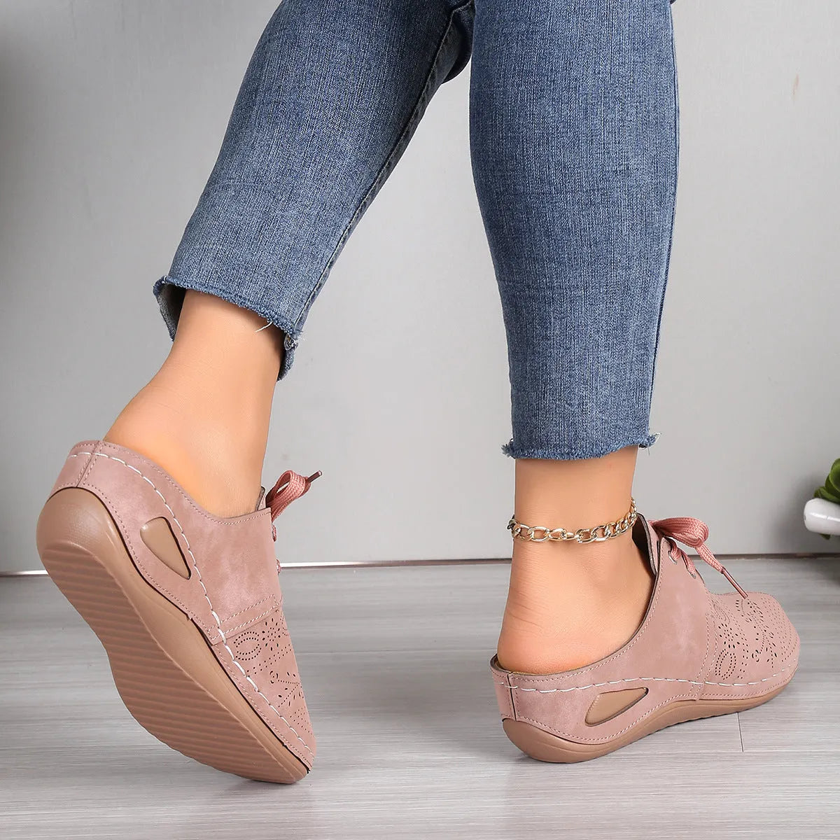 Women's black lace-up wedge slippers with a suede upper and hollow-out rubber sole on a light background.