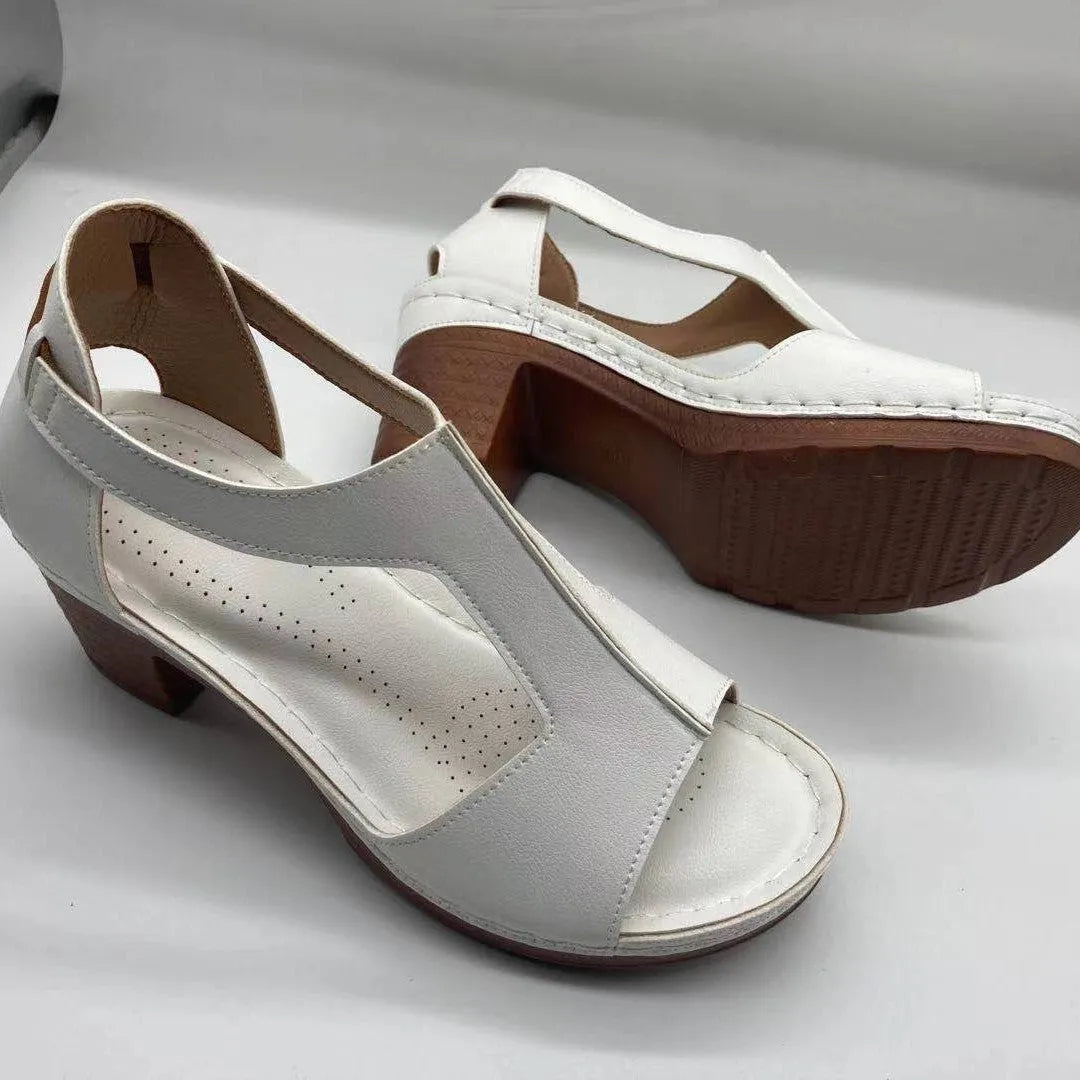 Women's beige peep toe wedge sandals with a Roman-style buckle strap on a low heel.
