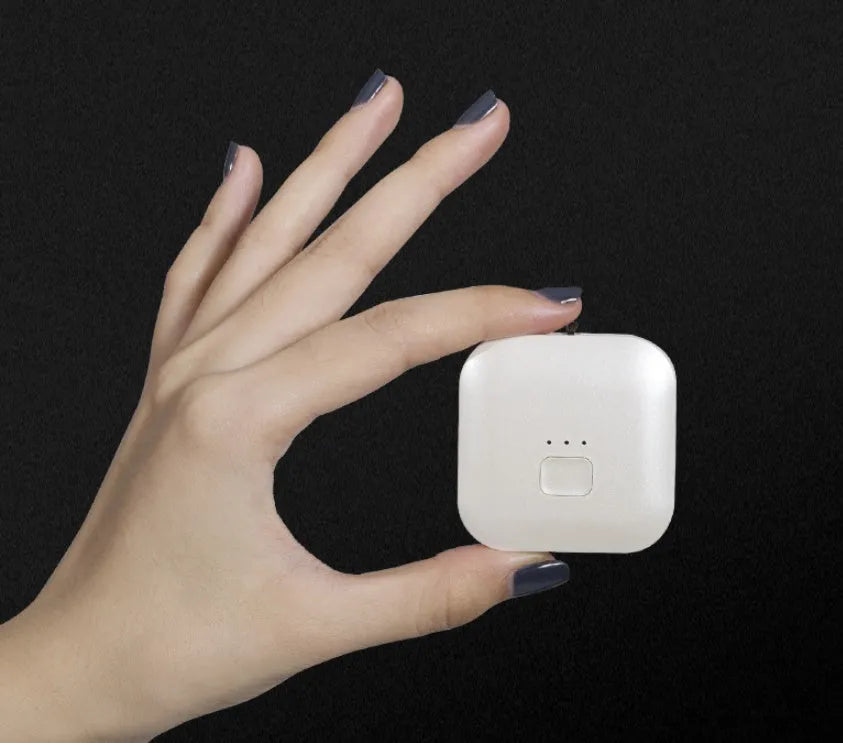 Pink and blue wearable USB air purifier necklace shown on a person, with dimensions 1.5 by 5.7 by 4.5 cm.