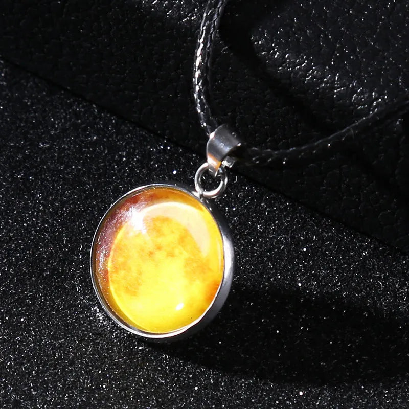 Close-up of a luminous alloy necklace with a blue organic glass constellation pendant on a model.