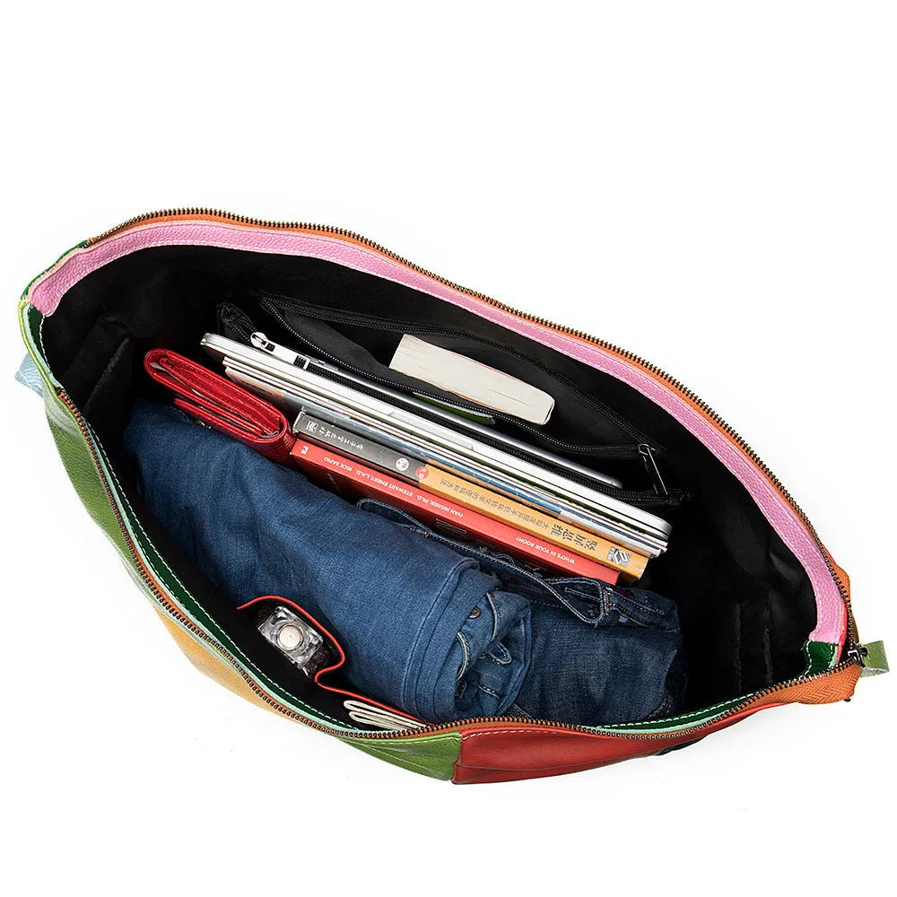 Brown cowhide leather crossbody travel bag open showing space for a laptop and personal items.