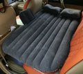 Black inflatable car bed with flocking material and two pillows, shown inside a car.