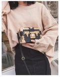 Hard-sided black PU leather women's shoulder bag with flap and decorative rivets.