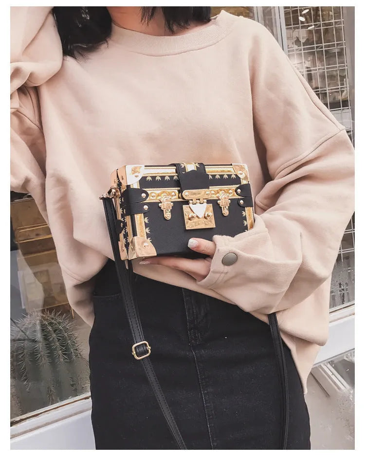 Hard-sided black PU leather women's shoulder bag with flap and decorative rivets.
