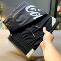 Men's solid black cropped trousers with banded ankle cuffs made from thin ice silk cotton fabric.
