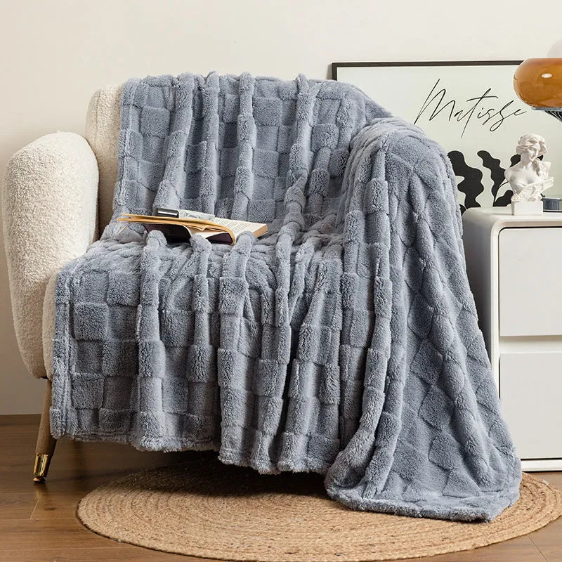 Thickened geometric pattern blanket in a neutral colour, draped over a modern sofa.