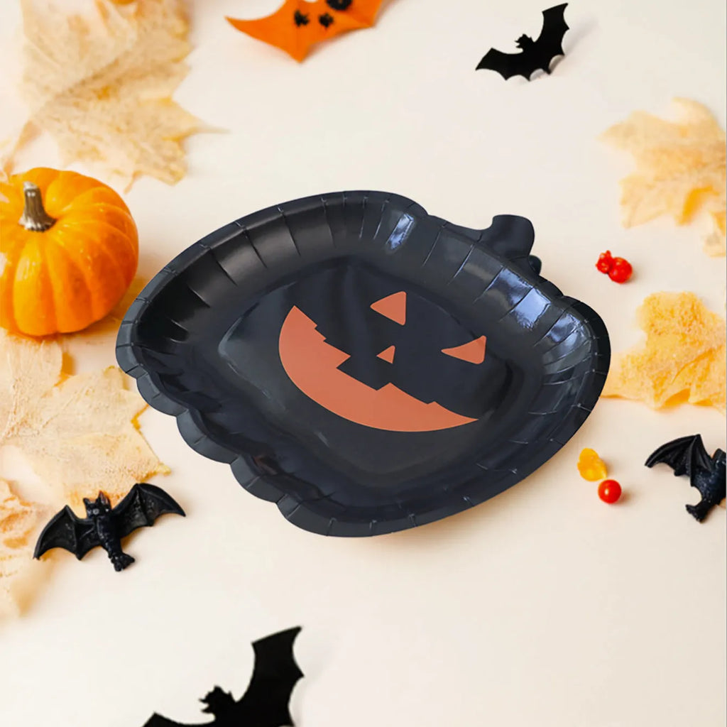 A pack of black disposable paper plates with a pumpkin design for Halloween, shown in 9-inch size.