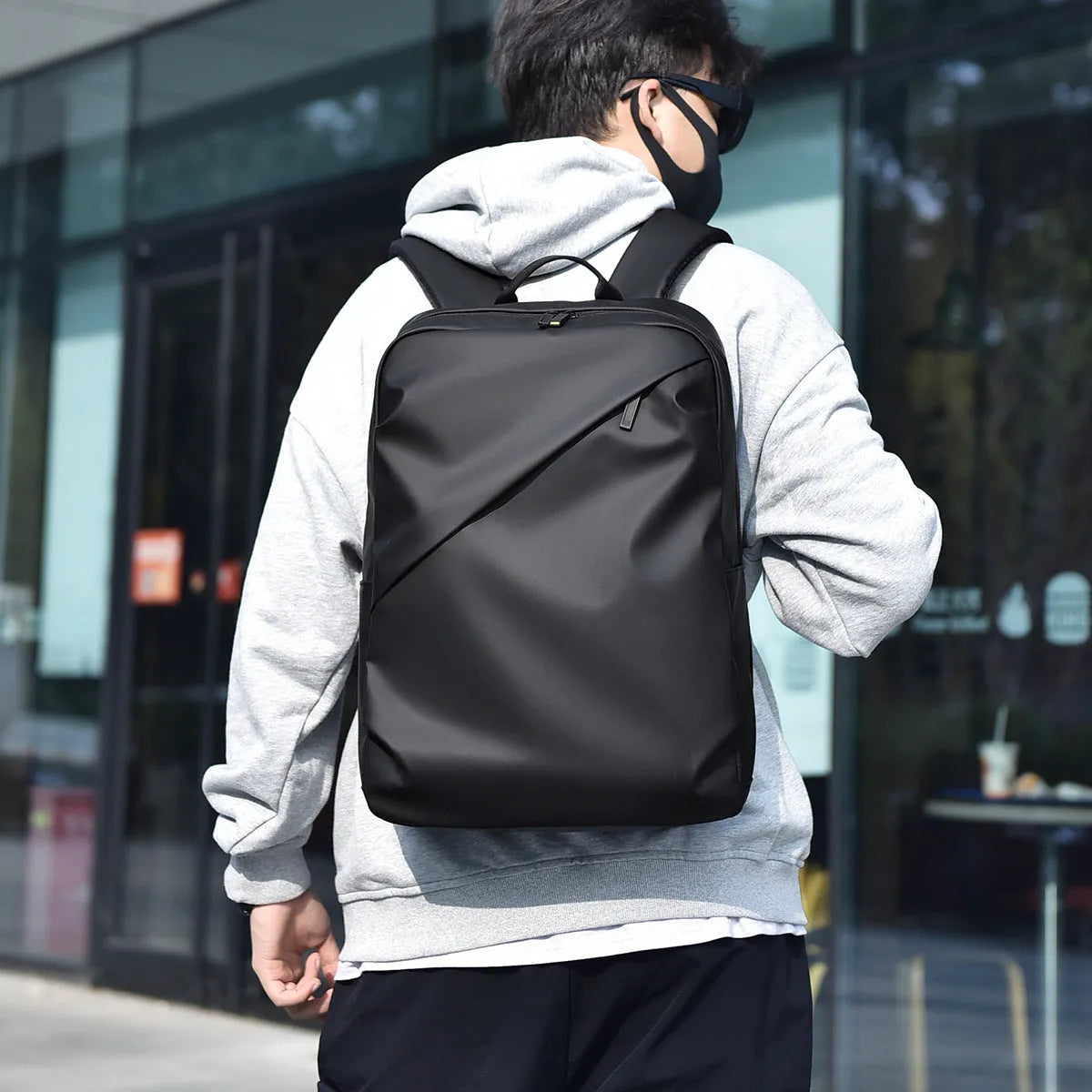 Waterproof large capacity black PU backpack with sewing thread detailing, shown closed.