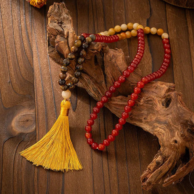 Bohemian-style long necklace chain with vintage tassel and matching bracelet on dark background