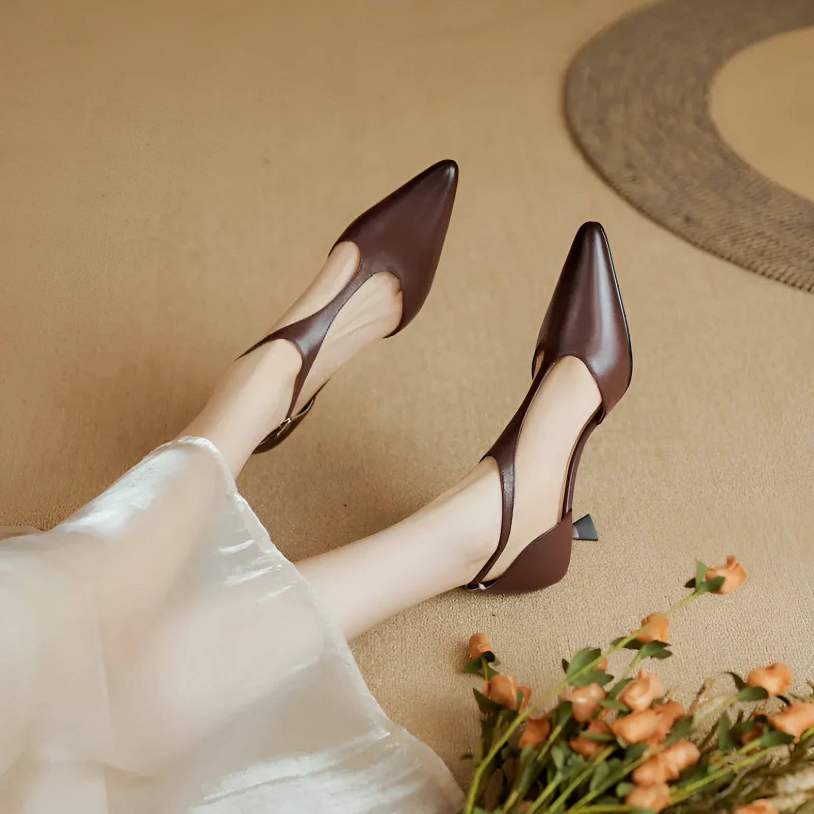Women's brown and black cowhide high heels with a pointed toe on a white background.