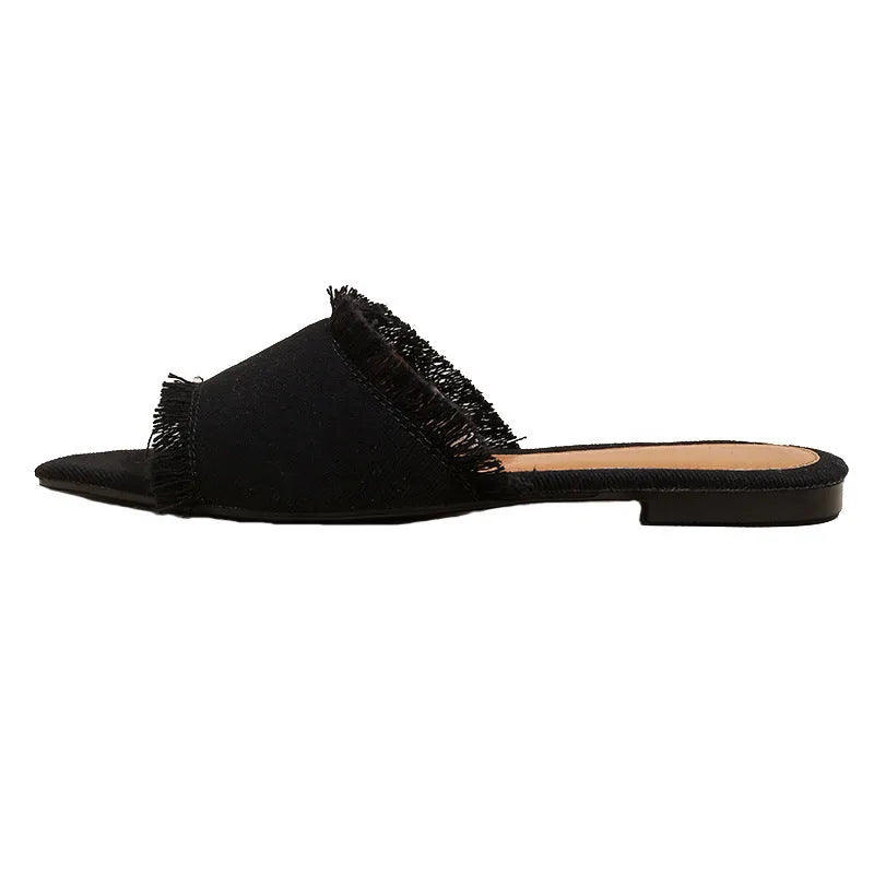 Women's denim flat slippers with a tassel detail and leather lining, shown in apricot colour.