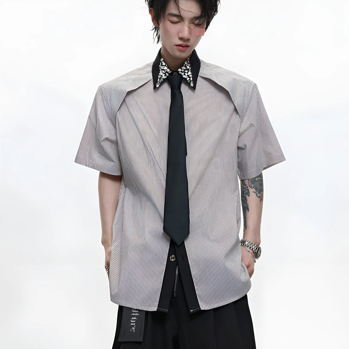 Men's blue and khaki patchwork striped shirt with diamond tie and quilted details, showing loose fit and flip collar.