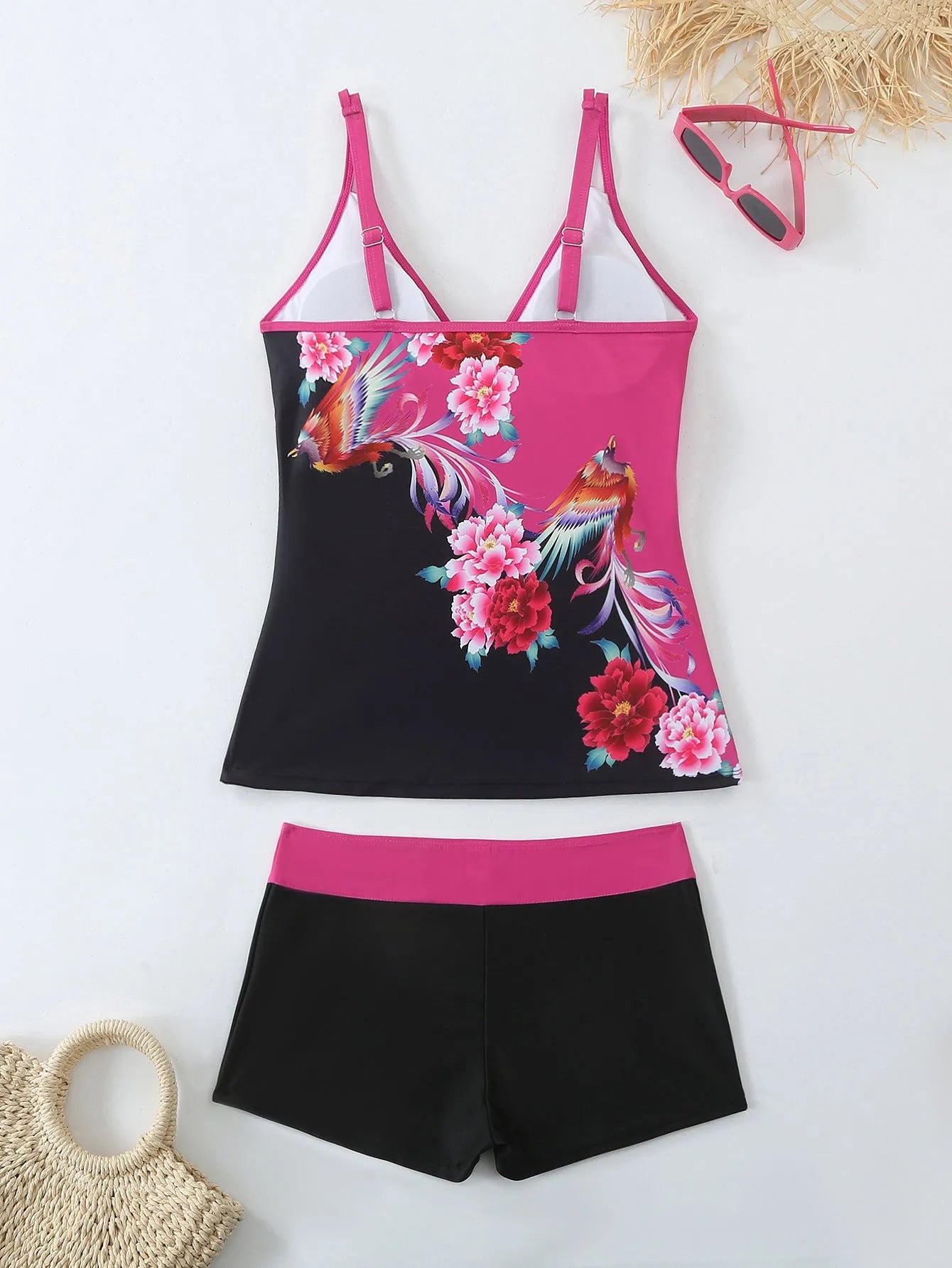 A plus size woman wearing a black two-piece printed swimsuit at the beach.