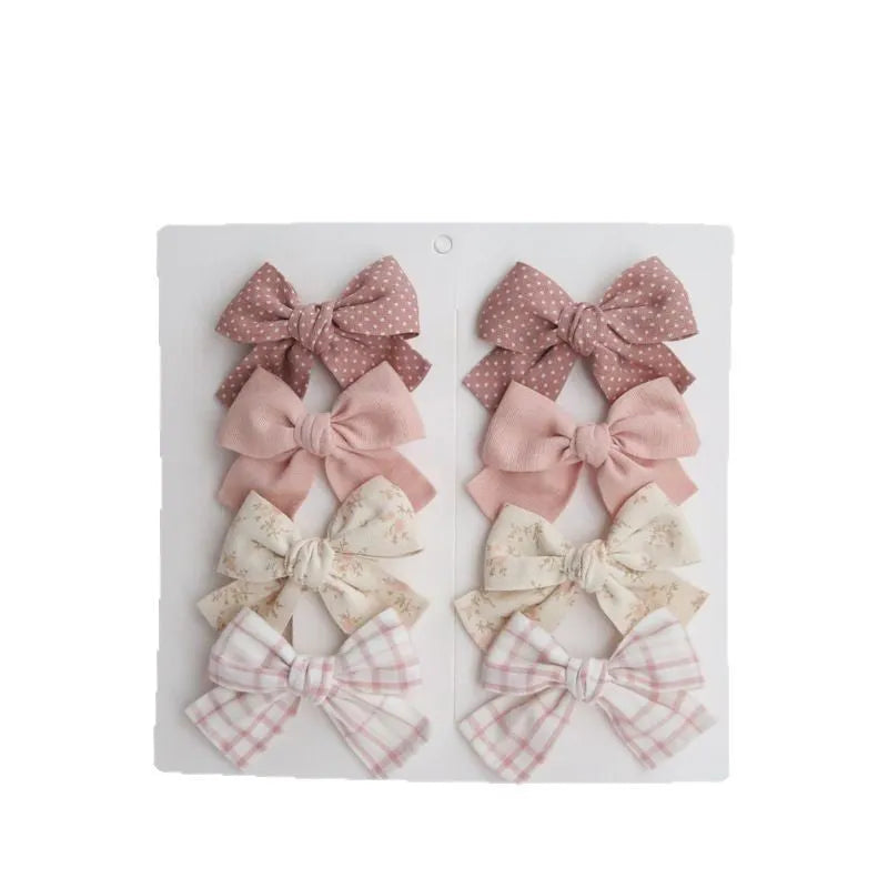 Set of eight fabric dovetail bow hairclips for children in various colours