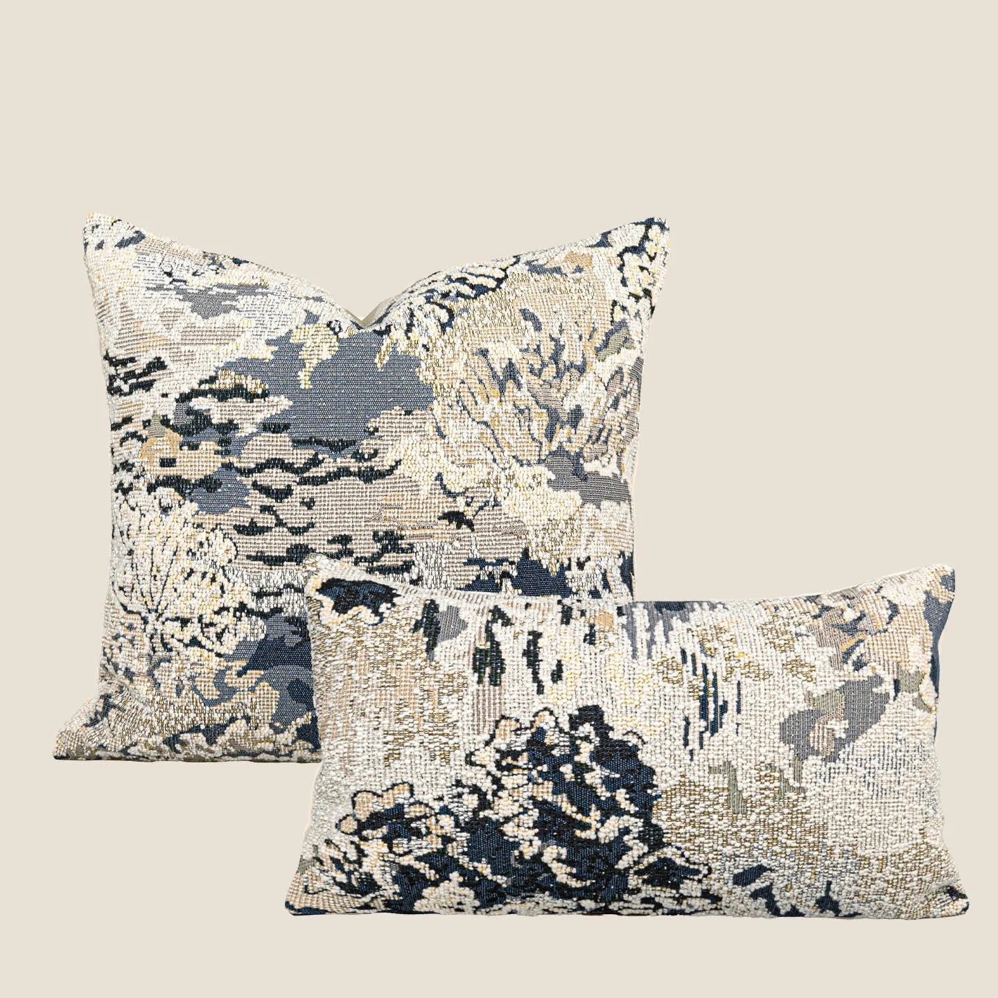 Antique blue French style decorative pillow with abstract floral pattern on a sofa.