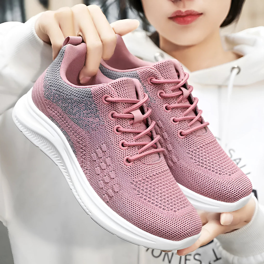 Women's low-top black mesh sneakers with a round toe and white PVC sole on a plain background.