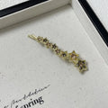 Gold-coloured alloy hair barrette with rhinestone star charm, shown clipped to hair.