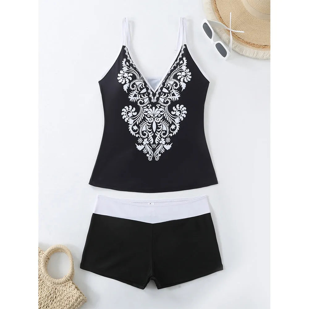 A plus size woman wearing a black two-piece printed swimsuit at the beach.