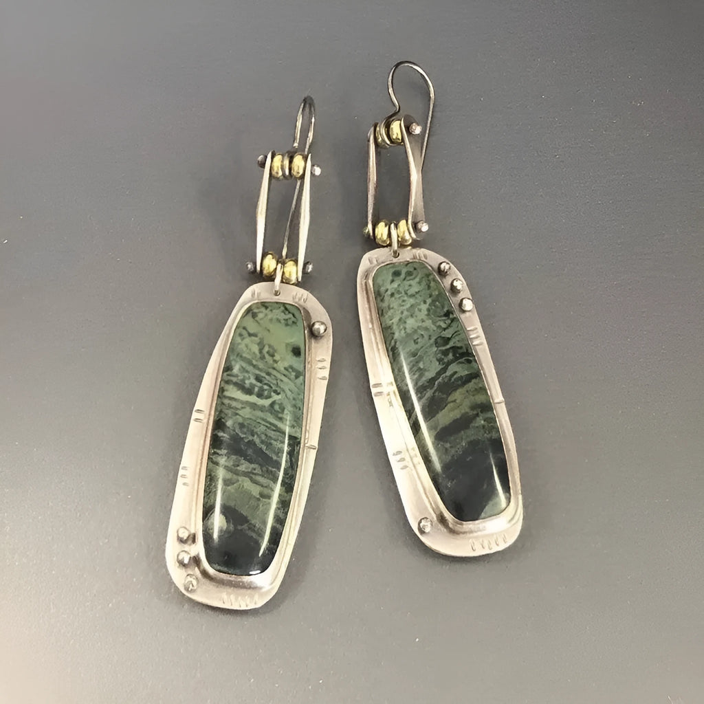 Geometric shaped drop earrings with a black and white marble pattern on an alloy metal backdrop.