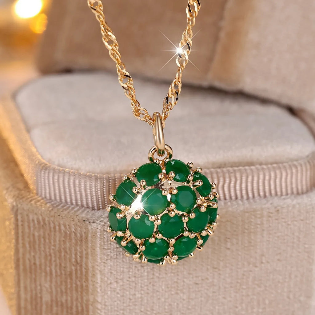 Round emerald pendant necklace with diamond setting on champagne gold chain