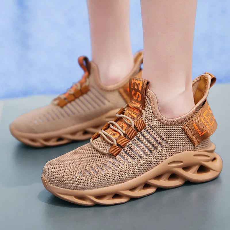 Children's Velcro sneakers in black, khaki, or white with fabric upper and textured sole.