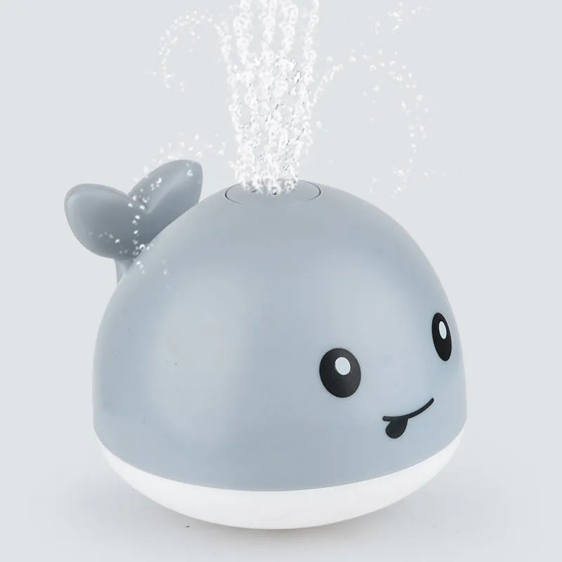 Electric whale bath toy spraying water with flashing LED lights in baby bath