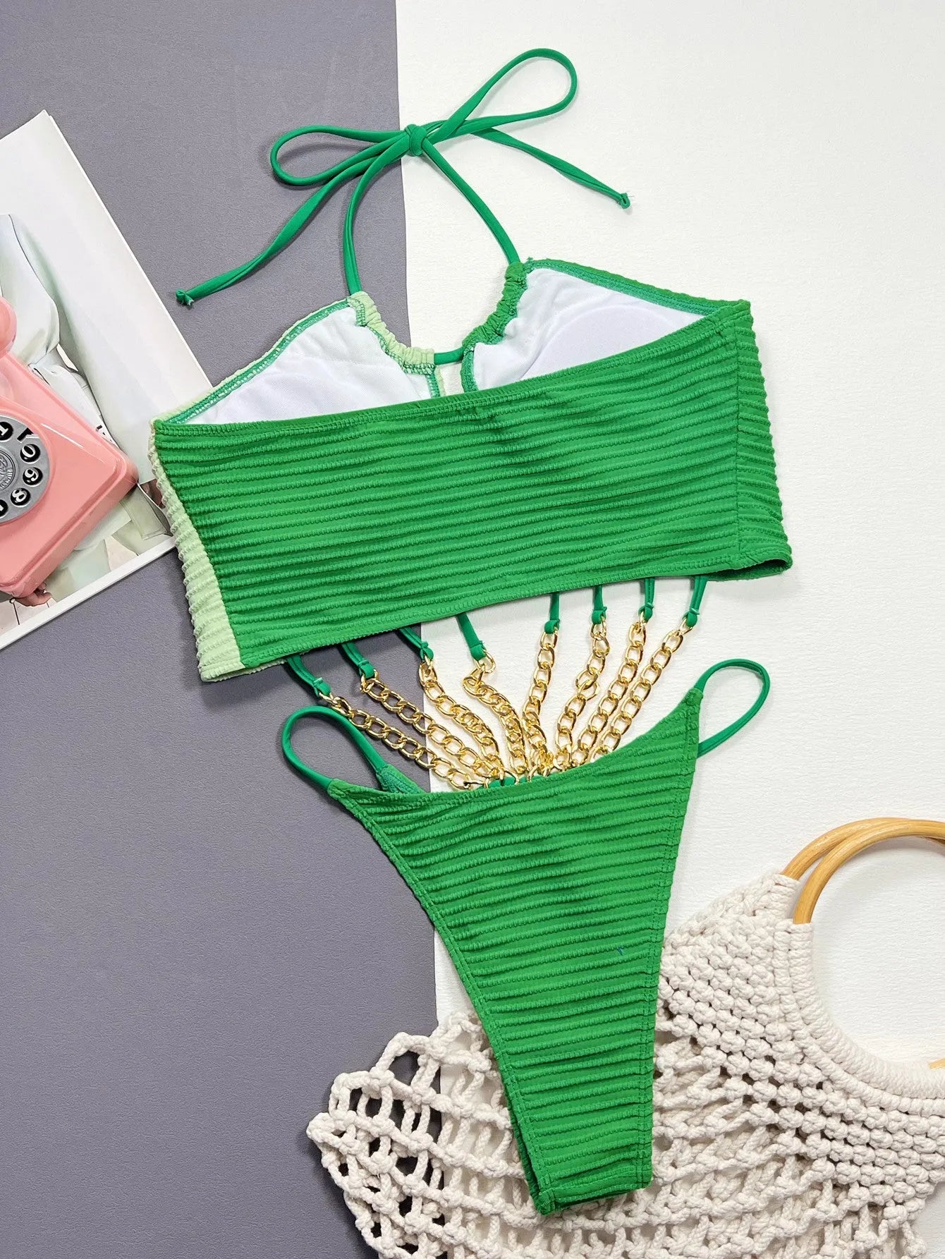 Green women's one-piece swimsuit with a hollow open back design on a mannequin.