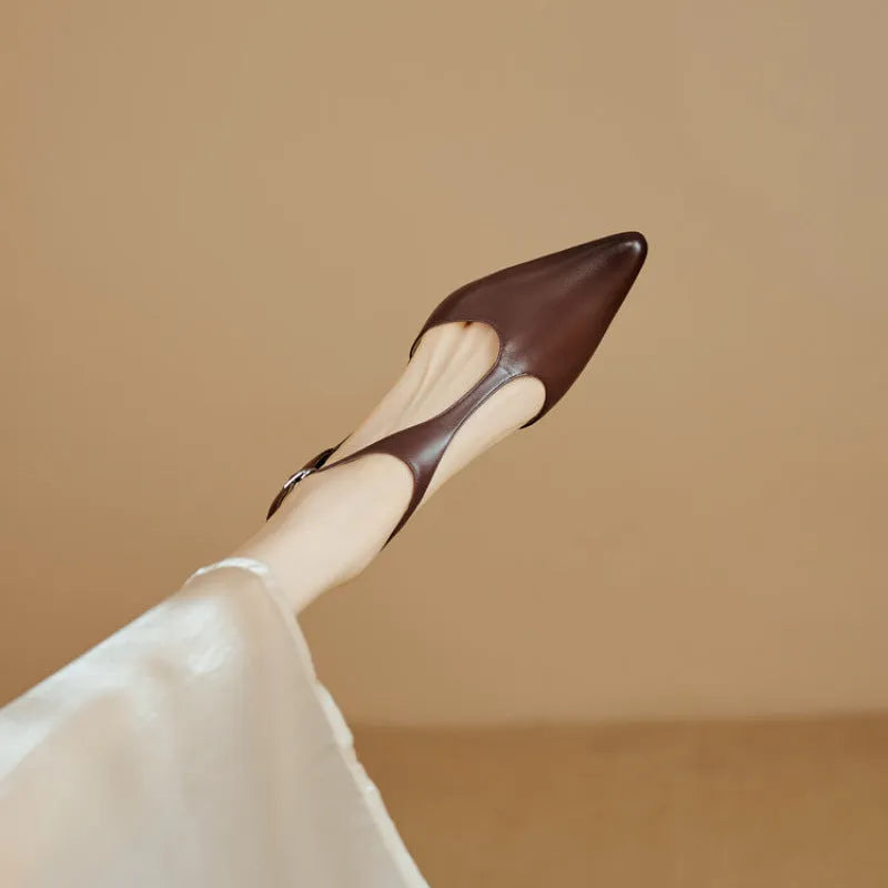 Women's brown and black cowhide high heels with a pointed toe on a white background.
