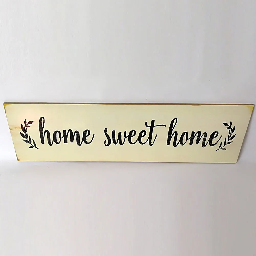 Black wooden wall plaque with carved white HOME SWEET HOME text, showing its rectangular shape.