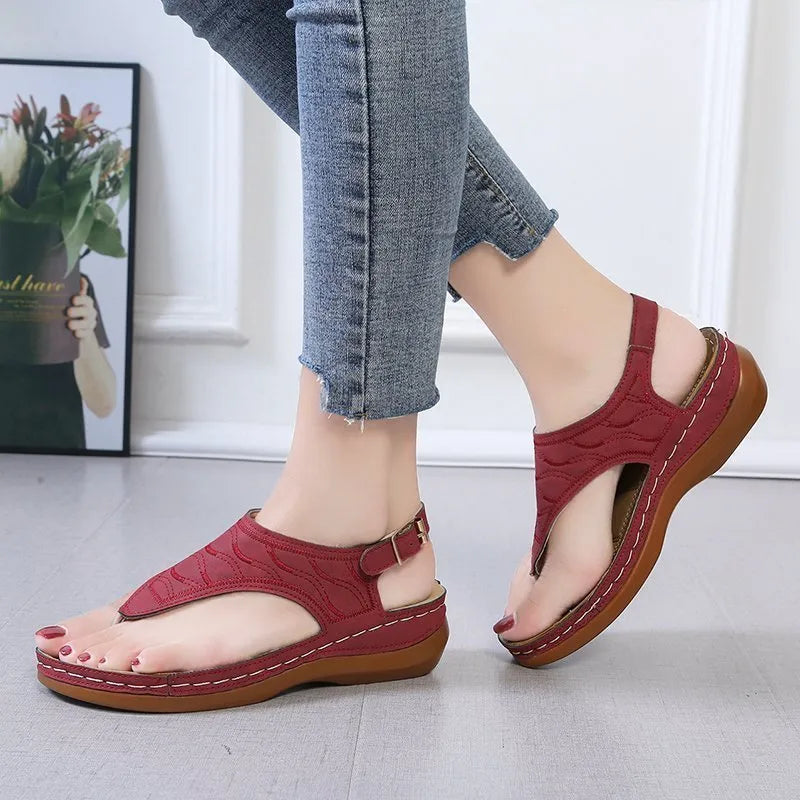 Women's wedge heel flip flop sandals in black with an adjustable back strap and buckle.
