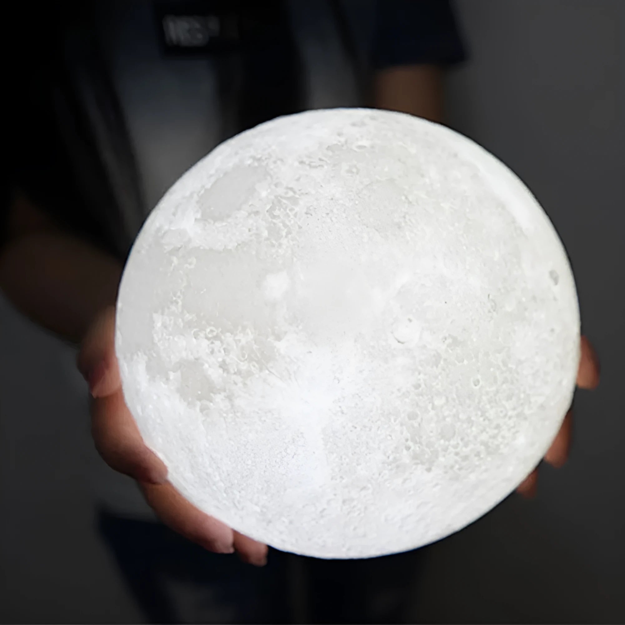 3D printed white moon lamp with textured surface on a wooden stand, showing touch ring at base.