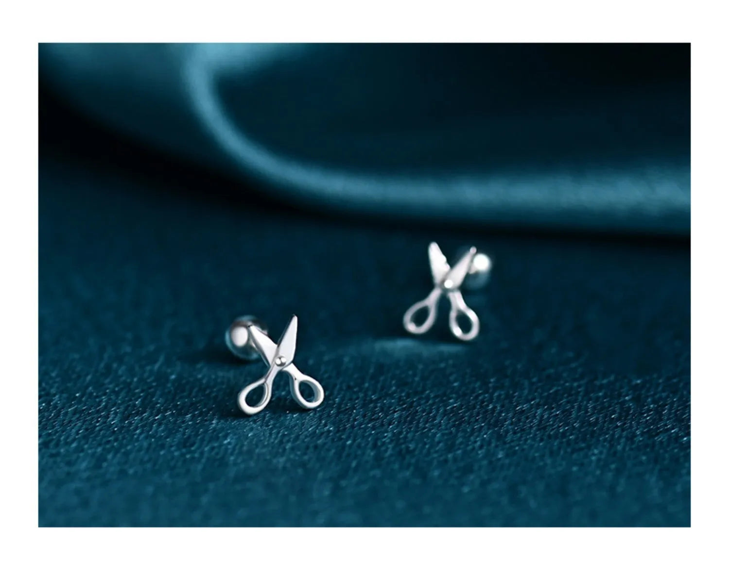 A pair of pure silver screw-back ear nails with a miniature scissors design.