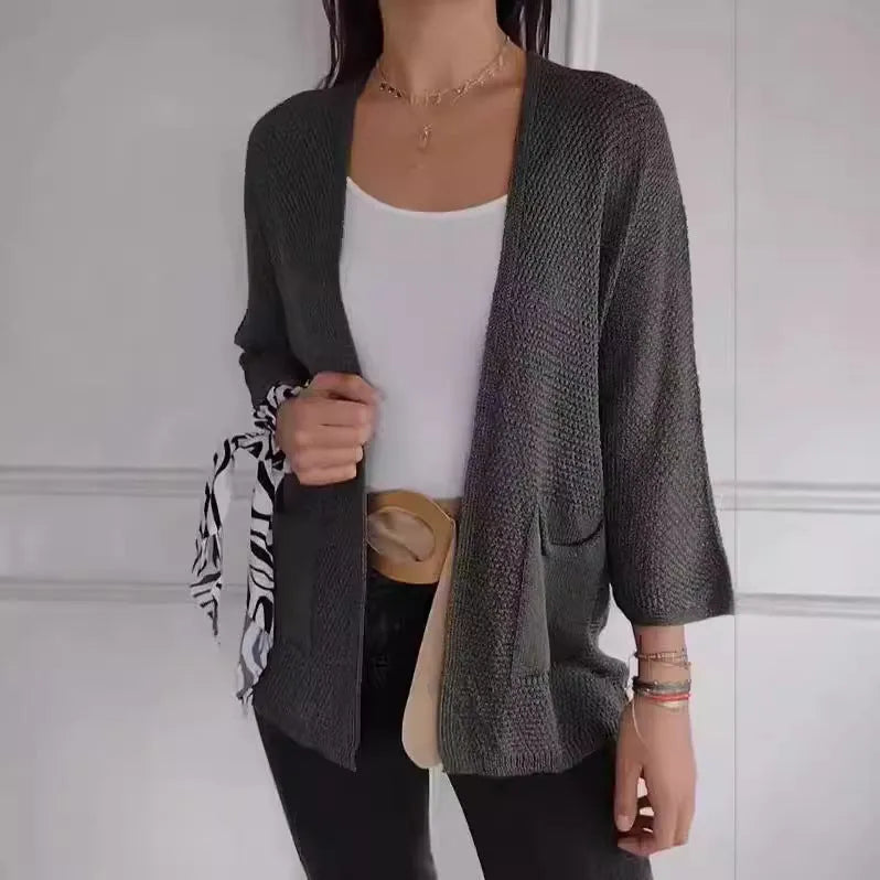 Women's army green waffle knit cardigan coat with nine-quarter sleeves and pockets laid flat.